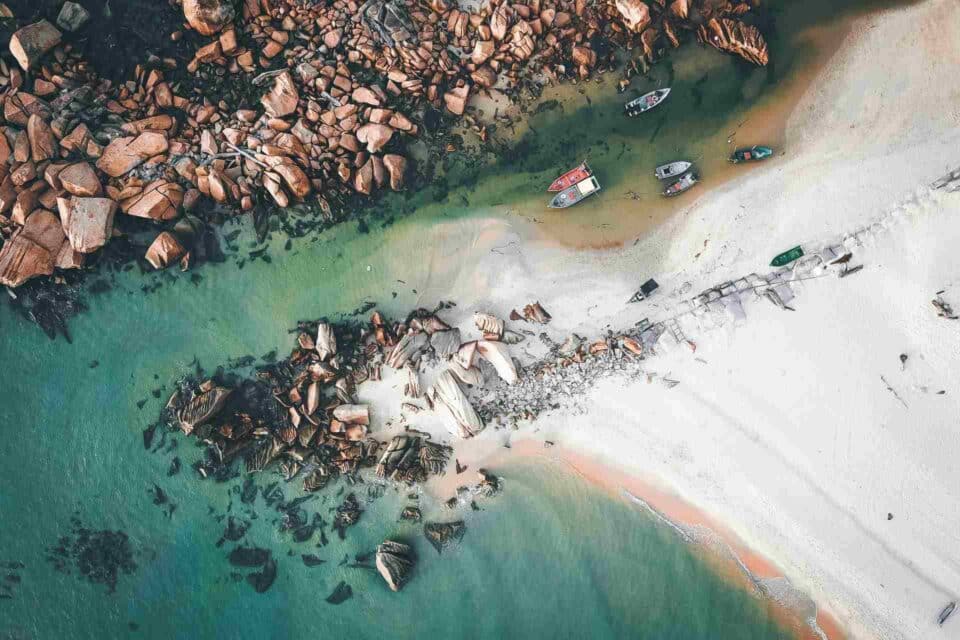 View from the sky to the beautiful sandy shore with few old boats